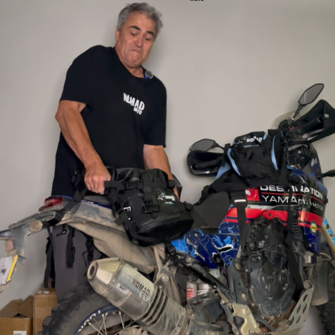 Man securing waterproof soft luggage on bike