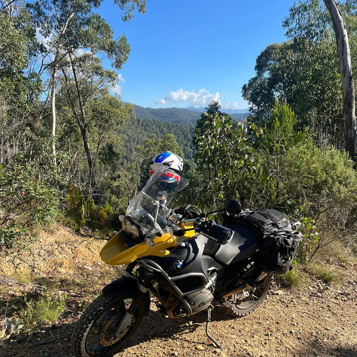 Nomad Moto Adjustable Rackless BMW 1200 GSA Motorcycle on a dirt road with trees and blue sky in the background