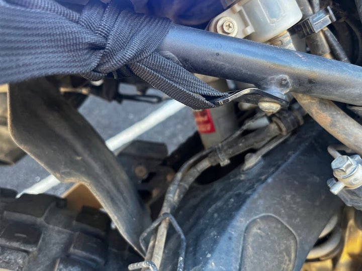 The luggage strap is looped tightly around the frame